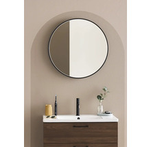 Badrum med tvättställsskåp, armatur, rund spegel och dekoration