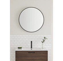 Badrum med rund spegel, handfat och blandare