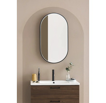 Badrum med tvättställsskåp, tvättställ och oval spegel