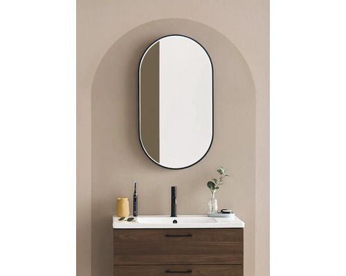 Badrum med tvättställsskåp, tvättställ och oval spegel