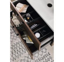 Öppna badrumslådor med diverse badrumsartiklar som en rakborste, handdukar och hudvårdsprodukter