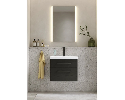 Badrum med tvättställsskåp, tvättställ, spegel med belysning och badrumstillbehör