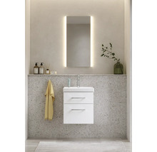 Badrum med tvättställsskåp, tvättställ, spegel med belysning och dekorationsartiklar