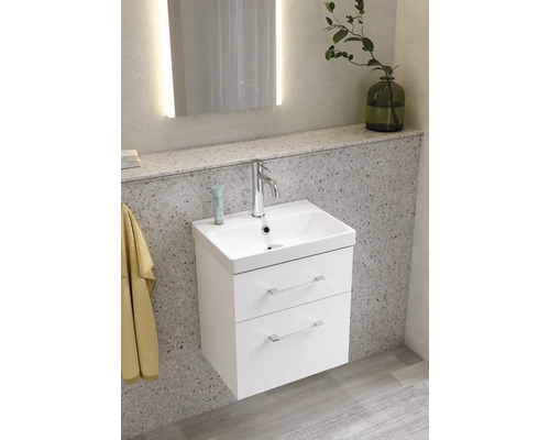 Badrumsscen med ett vitt tvättställsskåp med två lådor, ett handfat och en kran.