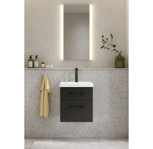 Badrumsscen med tvättställsskåp, tvättställ, spegel med belysning och dekoration