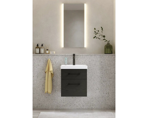 Badrumsscen med tvättställsskåp, tvättställ, spegel med belysning och dekoration