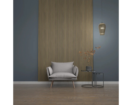 Vardagsrum med fåtölj, sidobord, pendellampa och väggpaneler