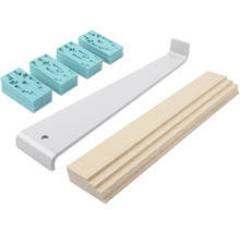 Läggningsset för laminat bestående av ett grått dragjärn av metall, en ljusbrun slagkloss av trä och turkosa distansklossar av plast.