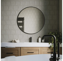 Modernt badrum med tvättställ, rund spegel och kakel