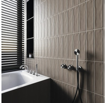 Modernt badrum med badkar, armaturer, hyllor och avlånga väggplattor