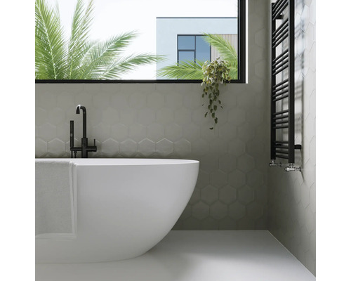 Badrum med badkar, handdukstork och sexkantiga väggplattor