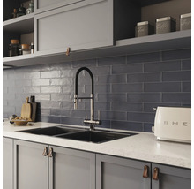 Köksscen med diskho, kran, kakel och köksredskap