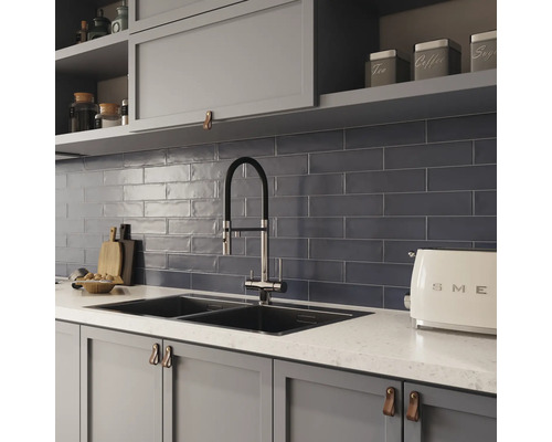 Köksscen med diskho, kran, kakel och köksredskap