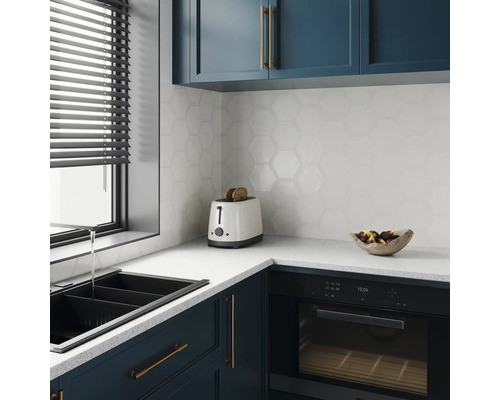 Modernt kök med diskho, brödrost, ugn och sexkantiga väggplattor.