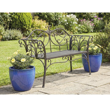 Dekorerad trädgårdsbänk i metall med blomkrukor på en trädgårdsterrass