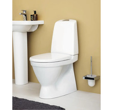 Vit golvstående toalett med cistern i badrumsmiljö