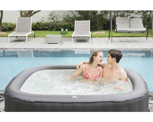 Scen med ett par i en uppblåsbar jacuzzi bredvid en pool, omgiven av solstolar och en gunga