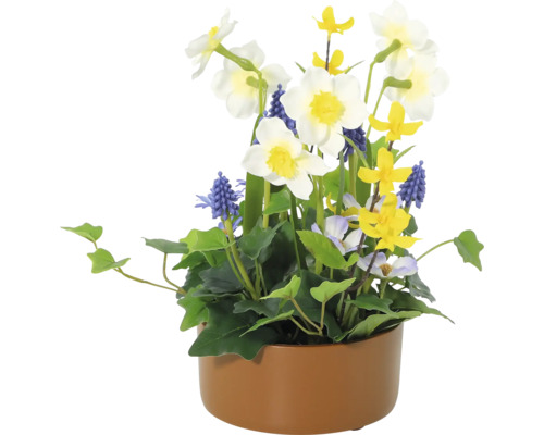 Dekorativt blomsterarrangemang med narcisser, pärlhyacinter och olika gröna växter i en planteringslåda.