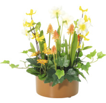 Dekorativa konstgjorda blommor i en kruka med påskliljor, ringblommor och gröna växter.