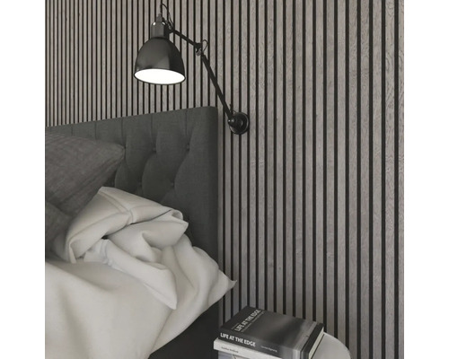 Modernt, ljust sovrum med akustikpaneler av träribbor, en stoppad sänggavel i tyg och en vägglampa i metall.