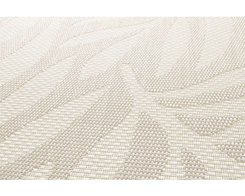 Detaljbild av en beige matta med vävt mönster