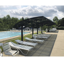 Poolområde med solstolar och tak.