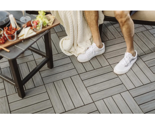 Kompositplattor på en terrass med bord och person