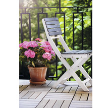 Fällbar trästol med blomkruka på en balkong