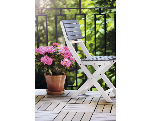 Fällbar trästol med blomkruka på en balkong