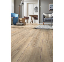 Laminatgolv i eklook i ett ljust, modernt inrett vardagsrum med soffa och matplats.