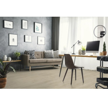Ljust golv med träutseende i ett modernt inrett vardagsrum och arbetsrum med grå soffa, skrivbord och strukturerad vägg.