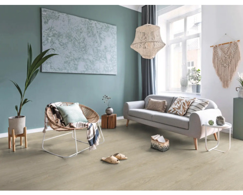 Ljust vardagsrum med golv i träoptik, grå soffa, korgfåtölj, stor taklampa och väggdekoration i boho-stil.