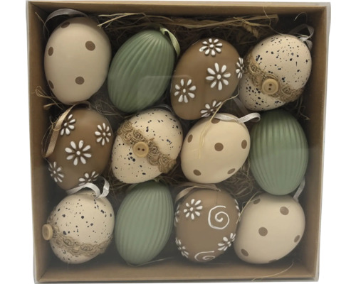 Set med tolv påskägg i olika mönster som prickar, blommor och ränder i en ask med halm.