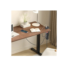 Grenuttag för skrivbord med USB portar på ett träbord i ett ljust och organiserat arbetsrum med laptop och lampa.