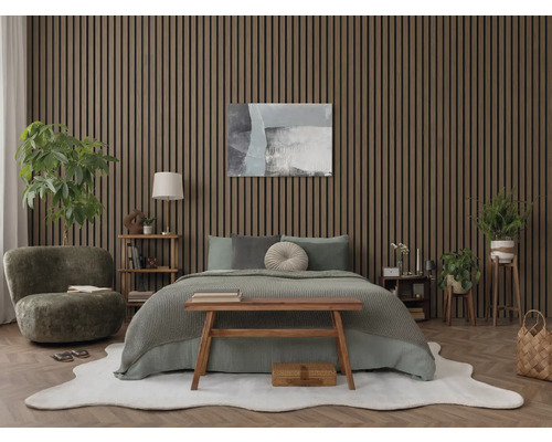 Modernt sovrum med akustikpaneler i trä på väggen, dubbelsäng med textilier och inomhusväxter på parkettgolv.