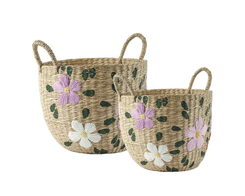 Set med två flätade korgar av sjögräs med broderade lila och vita blommor och gröna blad, var och en med två handtag.