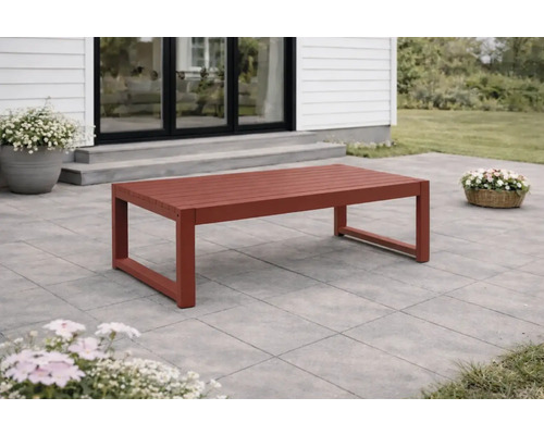 Rektangulärt loungebord i trä med ribbad yta på en stenlagd terrass framför ett hus.