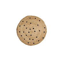 Rund jutesmatta med svarta prickar.