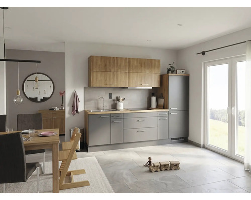 Modernt inbyggnadskök i grått och ekutförande med matplats, ljust klinkergolv och stort fönster.