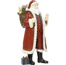 Jultomtefigur med en säck full av presenter på ryggen och ett paket vid fötterna, traditionell juldekoration.