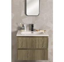 Modernt tvättställsskåp i trädekor med vitt tvättställ, svart blandare och spegel framför en vägg med geometriskt mönster.