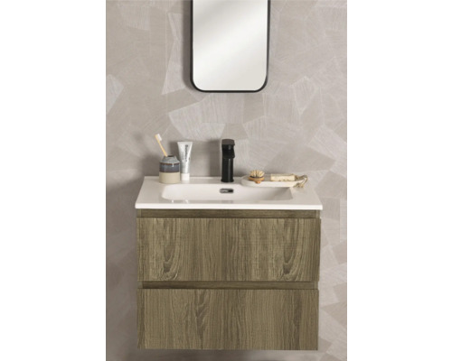 Modernt tvättställsskåp i trädekor med vitt tvättställ, svart blandare och spegel framför en vägg med geometriskt mönster.