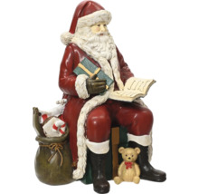 Dekorativ sittande jultomtefigur med ett paket, en bok, en säck med presenter och en nallebjörn.