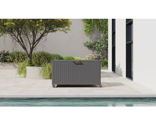 Mörkgrå trädgårdsbox i metall på hjul på en terrass vid en pool.