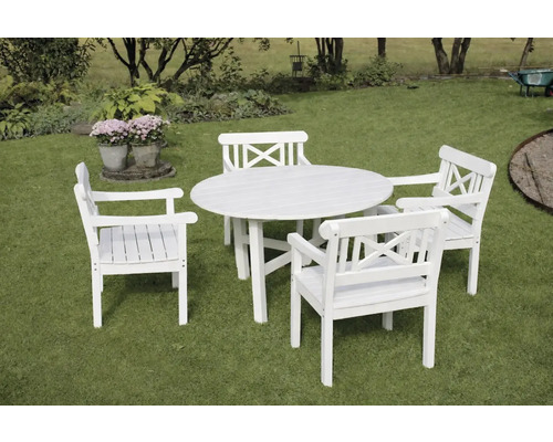 Vit trädgårdsgrupp med ett runt träbord och fyra karmstolar med kryssrygg på en gräsmatta.