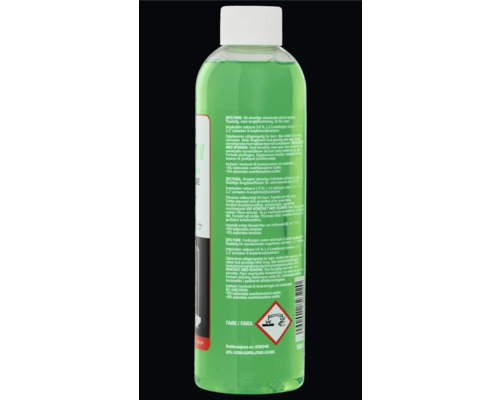 Baksida av en plastflaska med grön vätska, etikett med säkerhetsinstruktioner och farosymbol för frätande ämnen.