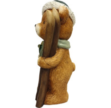 Dekorationsfigur björn med skidor, vintermössa och halsduk.