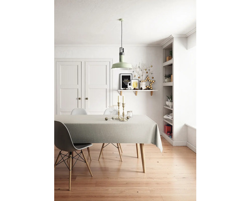 Ljust inredd matplats med trägolv, grådukat matbord, moderna stolar och juldekorationer på hyllan och bordet.