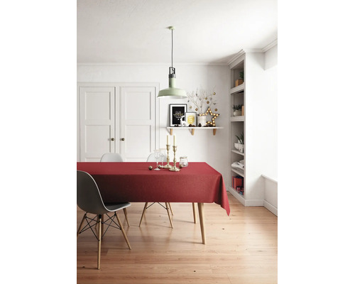 Ljust inrett matrum med röd bordsduk på träbord, moderna stolar, grön taklampa och juldekorationer.