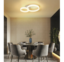 Modern LED-taklampa med två ringar i en ljus matsal med runt bord och stoppade stolar.